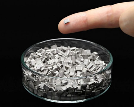 人差し指にのせた高純度アルミニウム粒